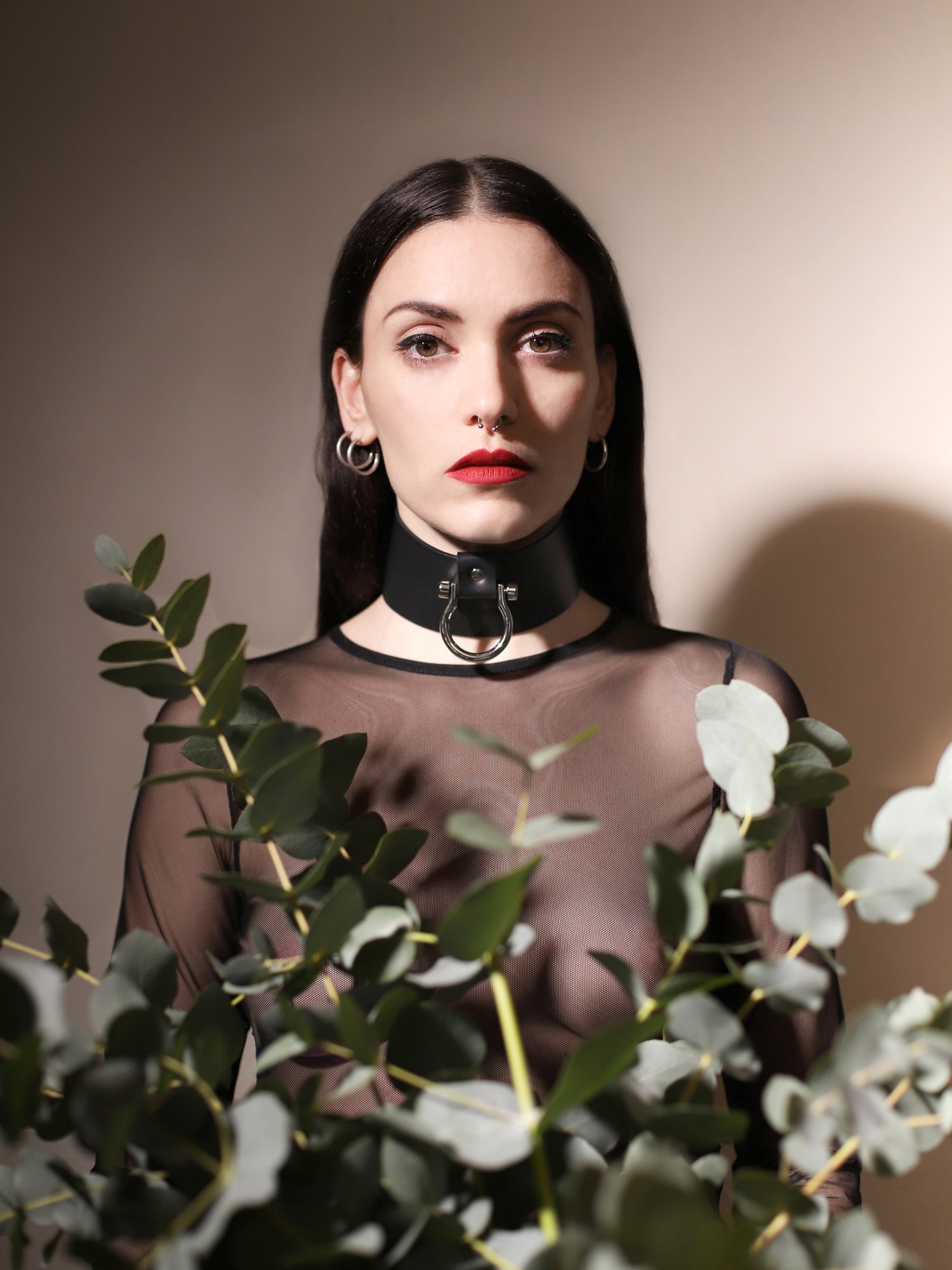 Gio standing behind plants wearing the Masha vegan choker by Baby turns Blue Paris