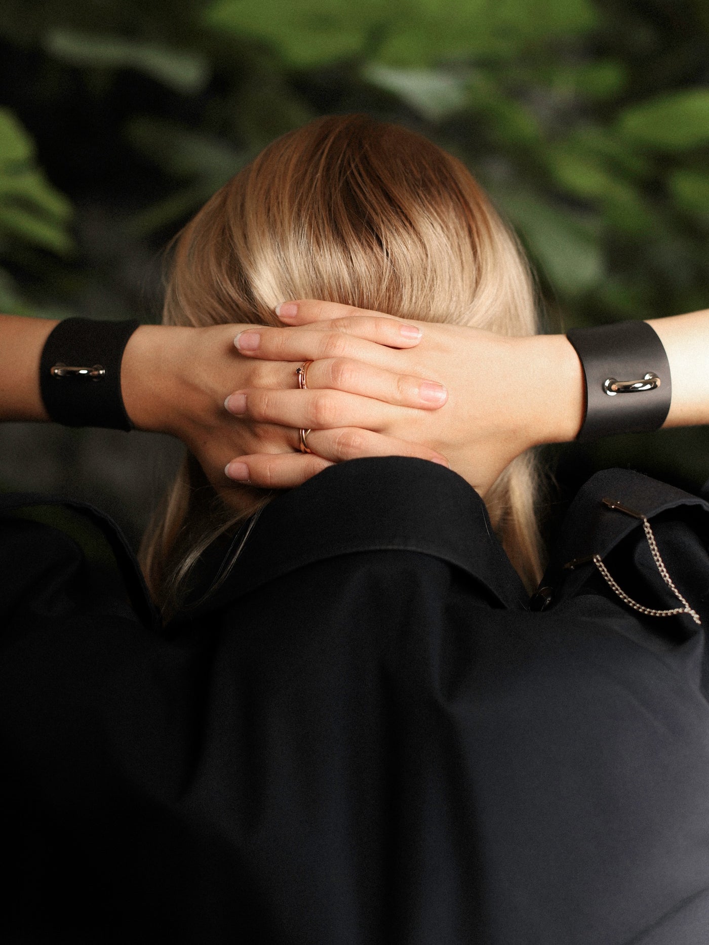 Model crossing hands above the head with a Dee cuff on each wrist
