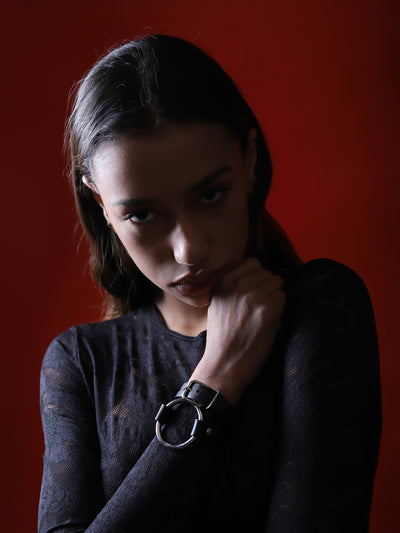 Ambre wearing the vegan leather Ella cuff with red background by Baby turns Blue Paris