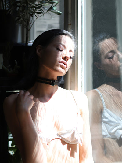 Celine sitting by the window with the eco-conscious Lola choker by Baby turns Blue Paris